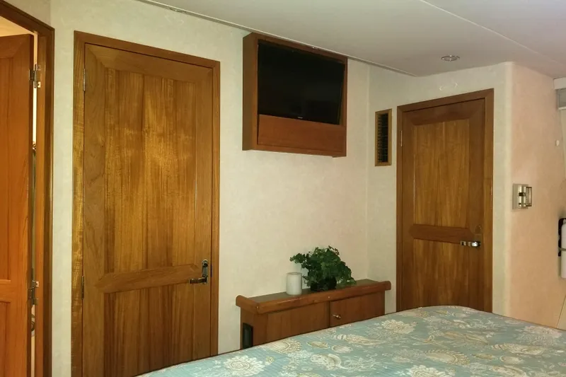 Slide: The Image of Interior of 1999 Pacific Mariner 65 Motoryacht bedroom with wooden doors and mounted TV. - 59