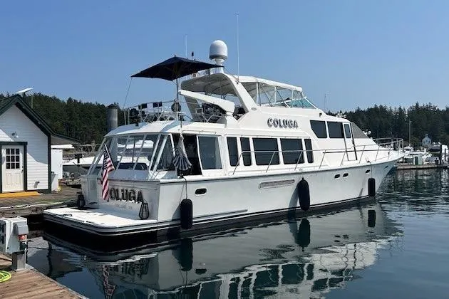 Slide: The Image of 1999 Pacific Mariner 65 Motoryacht docked at a marina, reflecting on calm water. - 6