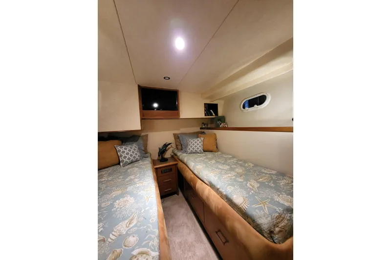 Slide: The Image of 1999 Pacific Mariner 65 Motoryacht cabin with twin beds and nautical-themed decor. - 65