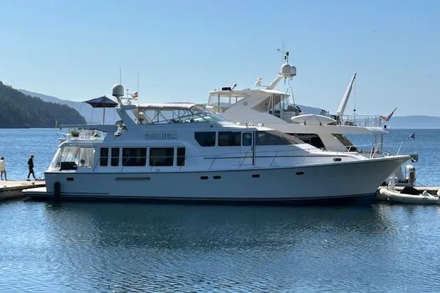 Slide: The Image of 1999 Pacific Mariner 65 Motoryacht docked in a serene marina setting. - 7