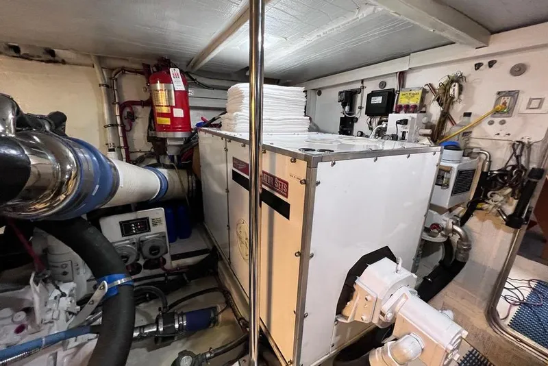 Slide: The Image of Engine room of a 1999 Pacific Mariner 65 Motoryacht, featuring machinery and equipment. - 77