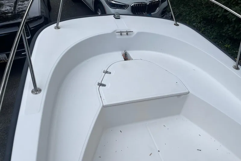 Slide: The Image of 2008 Boston Whaler 170 Montauk boat deck with storage compartment, surrounded by parked cars. - 4