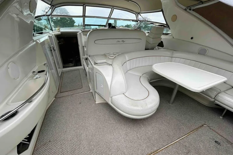 Slide: The Image of Interior of 1997 Sea Ray 450 Sundancer yacht with white seating and table. - 10