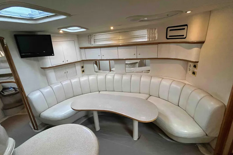 Slide: The Image of Luxurious interior of 1997 Sea Ray 450 Sundancer yacht with curved seating and table. - 14
