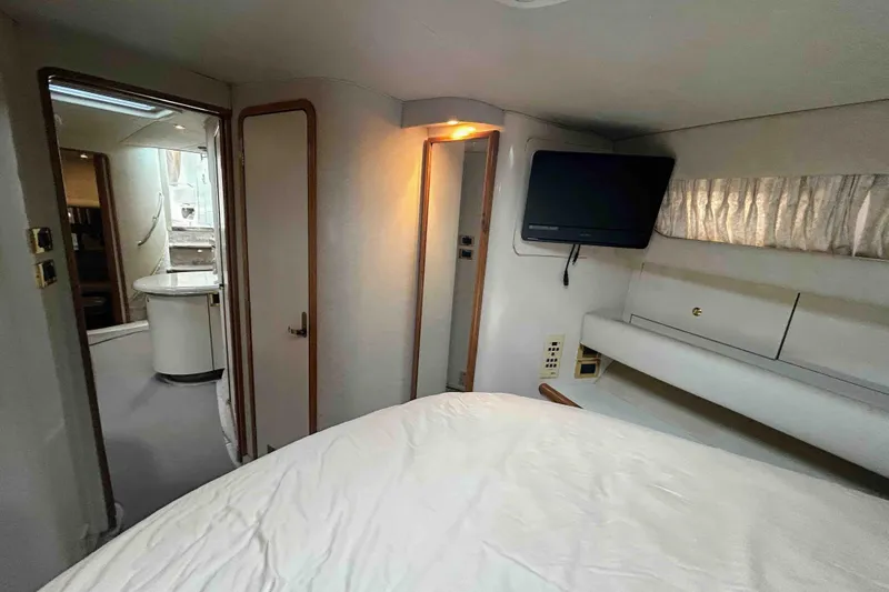 Slide: The Image of Interior of 1997 Sea Ray 450 Sundancer yacht with cozy bedroom and TV. - 16
