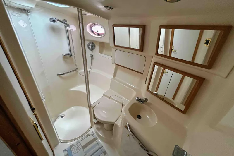 Slide: The Image of Bathroom interior of 1997 Sea Ray 450 Sundancer yacht, featuring shower, sink, and mirrors. - 5
