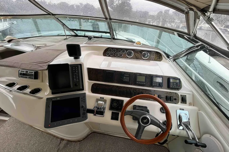 Slide: The Image of 1997 Sea Ray 450 Sundancer helm with navigation instruments and wooden steering wheel. - 7