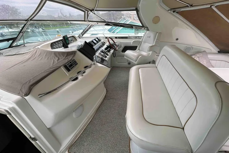 Slide: The Image of 1997 Sea Ray 450 Sundancer cockpit with white seating and control panel. - 8