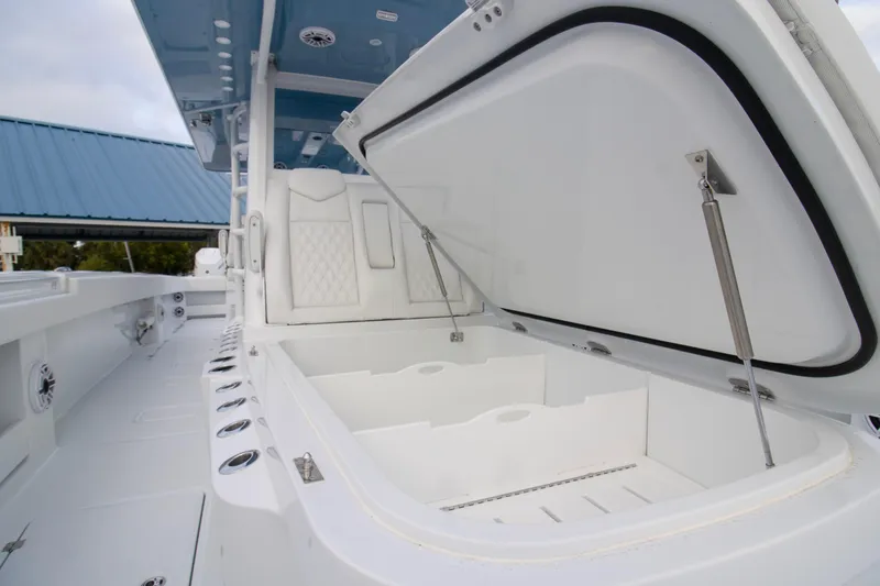 Slide: The Image of 2026 Invincible 38 Catamaran with open storage compartment and sleek white interior design. - 10