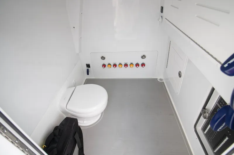 Slide: The Image of Interior of 2026 Invincible 38 Catamaran, featuring a compact marine toilet and control panel. - 14