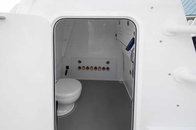 Slide: The Image of Interior of 2026 Invincible 38 Catamaran showing compact marine toilet and control panel. - 15