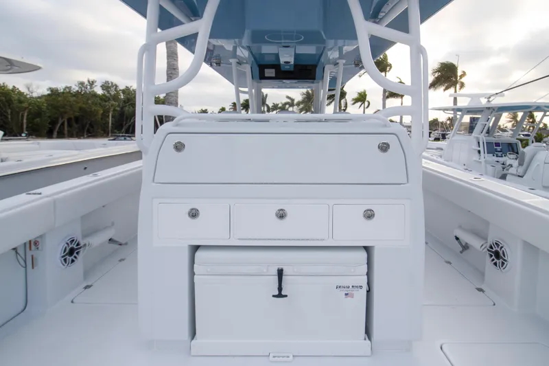 Slide: The Image of 2026 Invincible 38 Catamaran interior with storage compartments and cooler, docked near palm trees. - 17