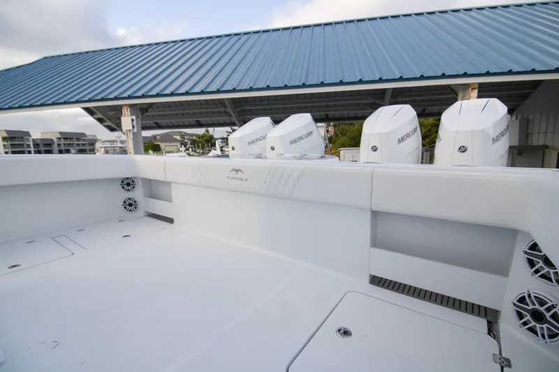 Slide: The Image of 2026 Invincible 38 Catamaran with Mercury engines, docked under a blue metal roof. - 20