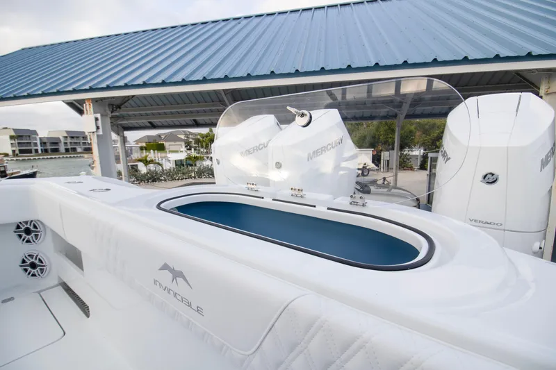 Slide: The Image of 2026 Invincible 38 Catamaran with Mercury engines, docked under a blue roof. - 22