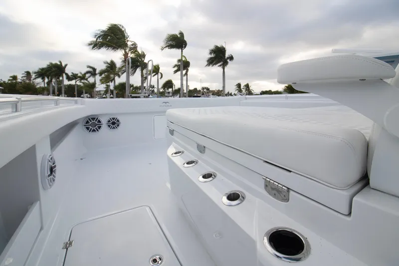 Slide: The Image of 2026 Invincible 38 Catamaran deck with white seating and palm trees in background. - 4