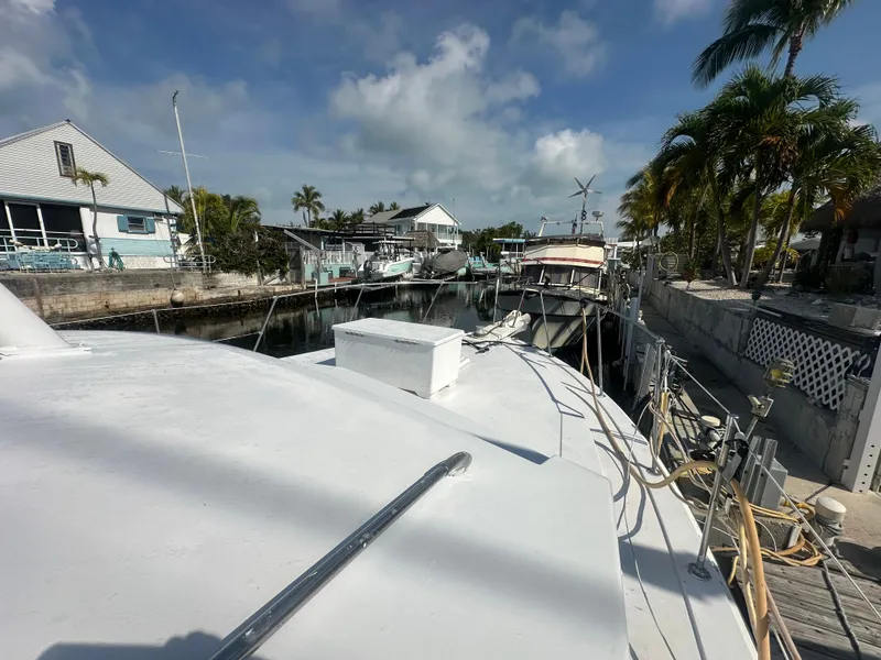 Slide: The Image of 1974 Bertram 42 Motor Yacht docked in a sunny marina with palm trees. - 10
