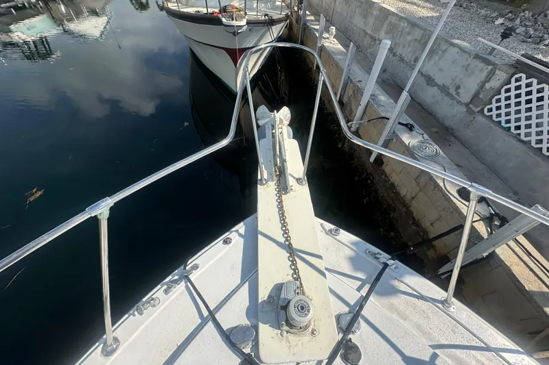 Slide: The Image of Bow view of a 1974 Bertram 42 Motor Yacht docked at a marina. - 13