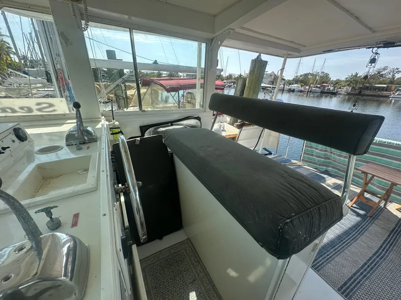 Slide: The Image of 1974 Bertram 42 Motor Yacht helm with black cushioned seat, docked at marina. - 30