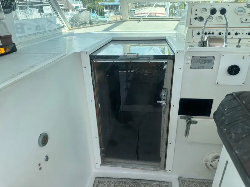 Slide: The Image of 1974 Bertram 42 Motor Yacht cockpit with control panel and cabin door. - 36