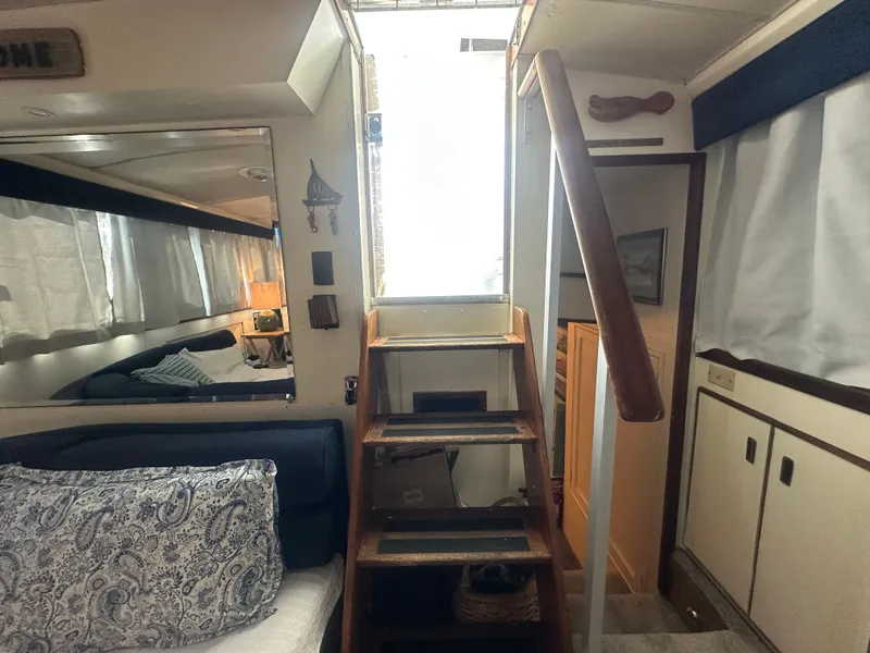 Slide: The Image of Interior of a 1974 Bertram 42 Motor Yacht with wooden stairs and cozy seating area. - 38