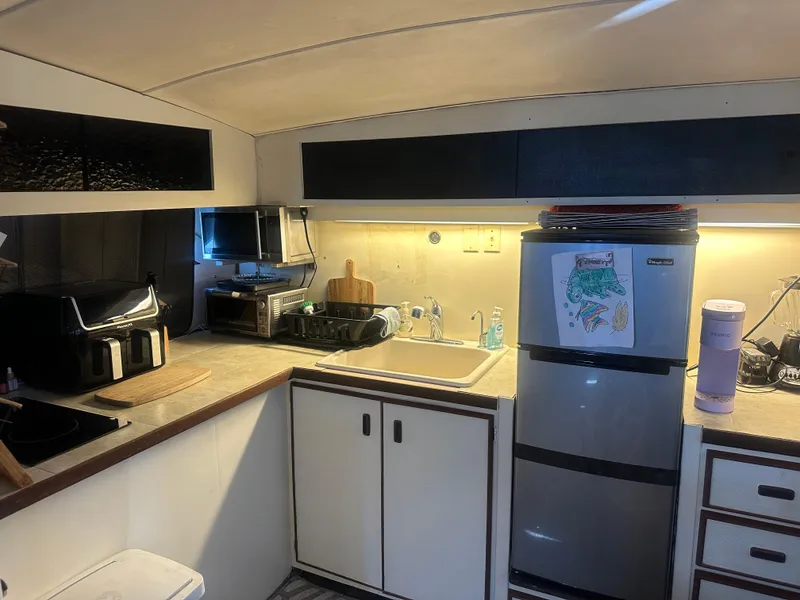 Slide: The Image of 1974 Bertram 42 Motor Yacht kitchen with modern appliances and compact design. - 44