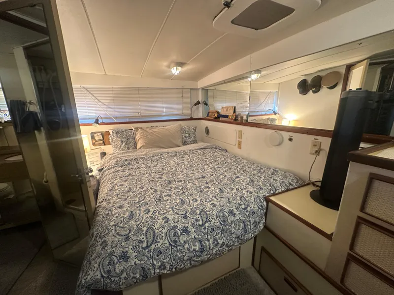 Slide: The Image of 1974 Bertram 42 Motor Yacht bedroom with patterned bedding and cozy interior design. - 46