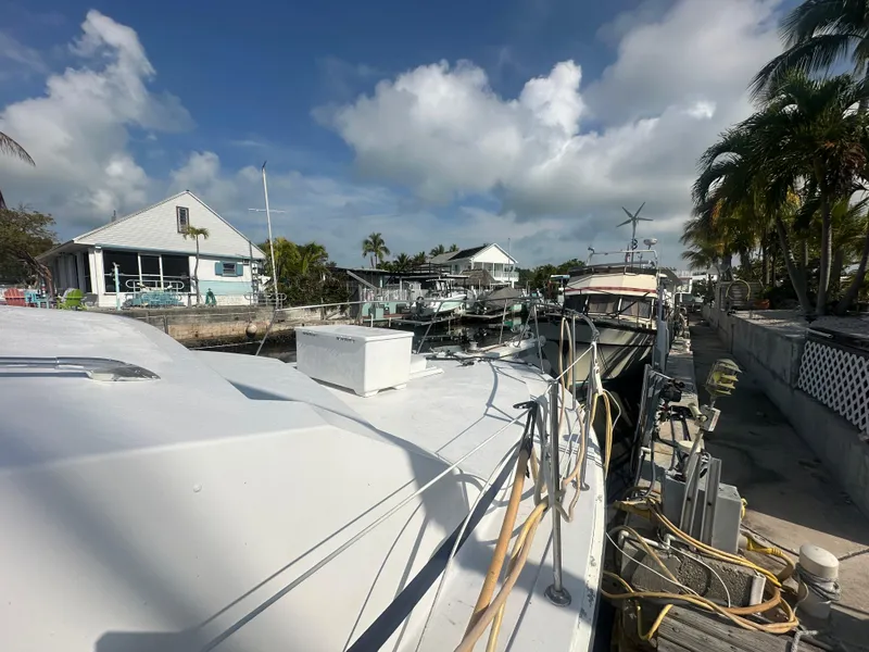 Slide: The Image of 1974 Bertram 42 Motor Yacht docked at a marina under a partly cloudy sky. - 5