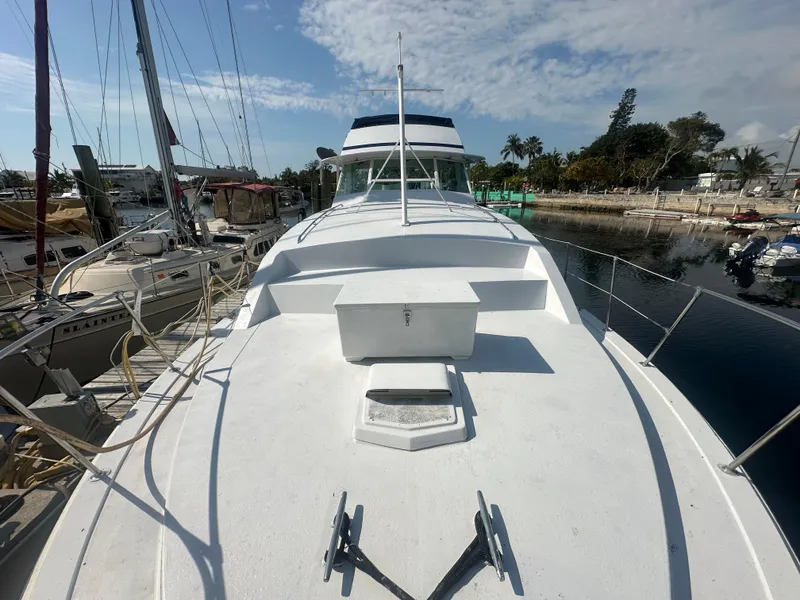Slide: The Image of 1974 Bertram 42 Motor Yacht docked, showcasing spacious deck and sleek design under clear skies. - 8