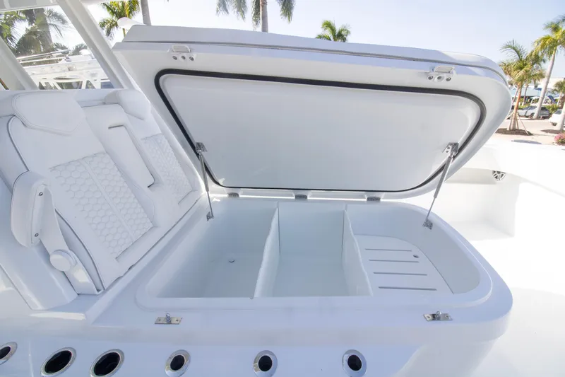 Slide: The Image of 2026 Invincible 36 Catamaran with sleek seating, docked near tropical foliage and modern architecture. - 3