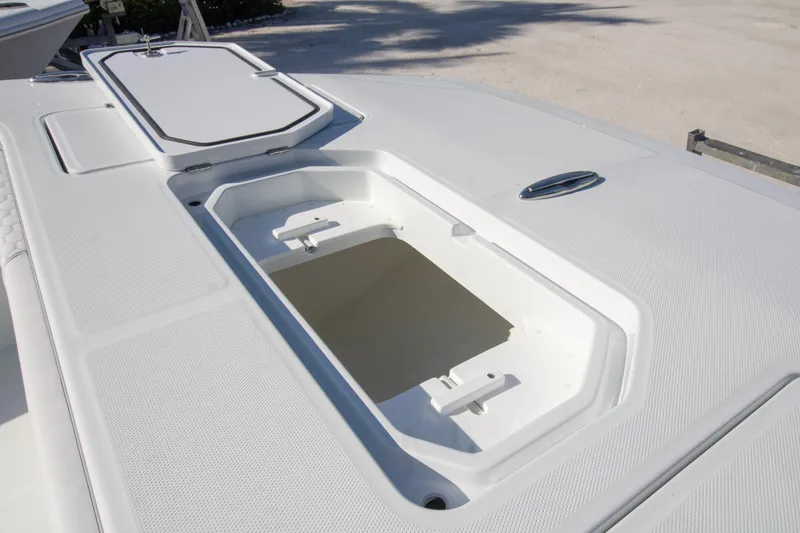 Slide: The Image of Open storage compartment on 2026 Invincible 36 Catamaran, featuring sleek white design and seating. - 5