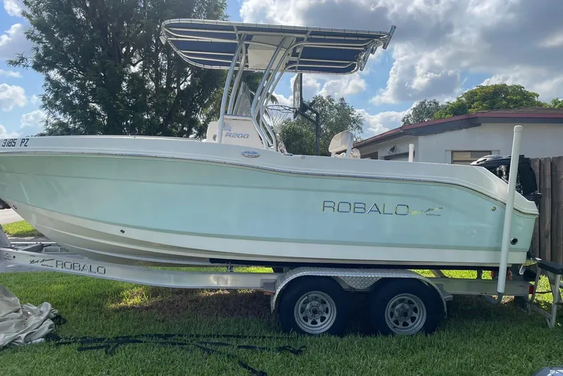 The Image of 2016 Robalo R200 Center Console boat on trailer, parked on grass. - 1