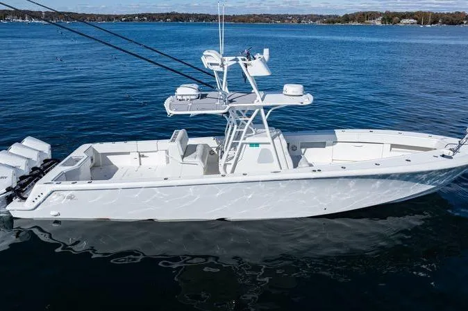 Slide: The Image of 2016 SeaVee 390Z boat on calm water, featuring a sleek white design and multiple outboard engines. - 2