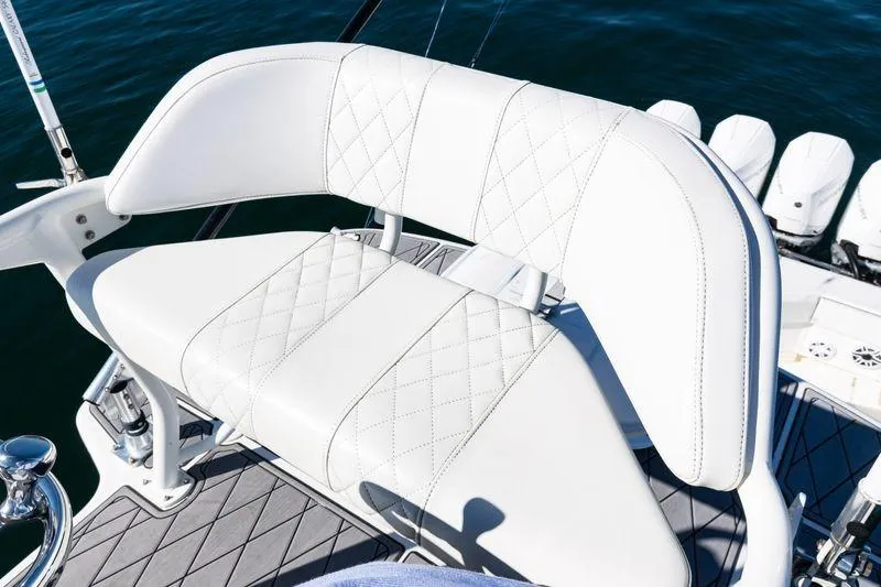 Slide: The Image of White leather seating on 2016 SeaVee 390Z boat, featuring diamond stitching and ocean backdrop. - 51