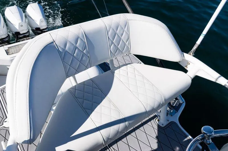Slide: The Image of White leather seating on 2016 SeaVee 390Z boat, with triple outboard motors in background. - 52