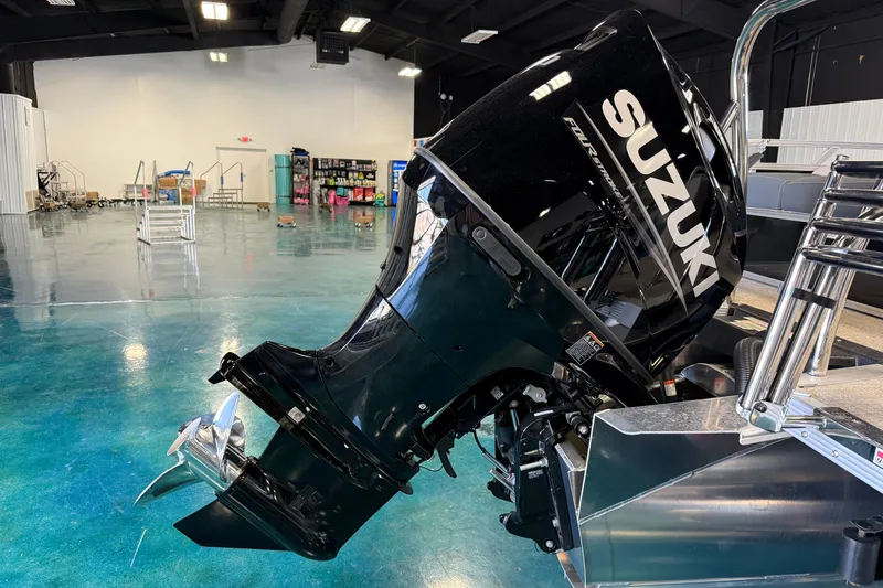 Slide: The Image of 2026 Tahoe Pontoon LTZ Entertainer with Suzuki outboard motor in showroom. - 17