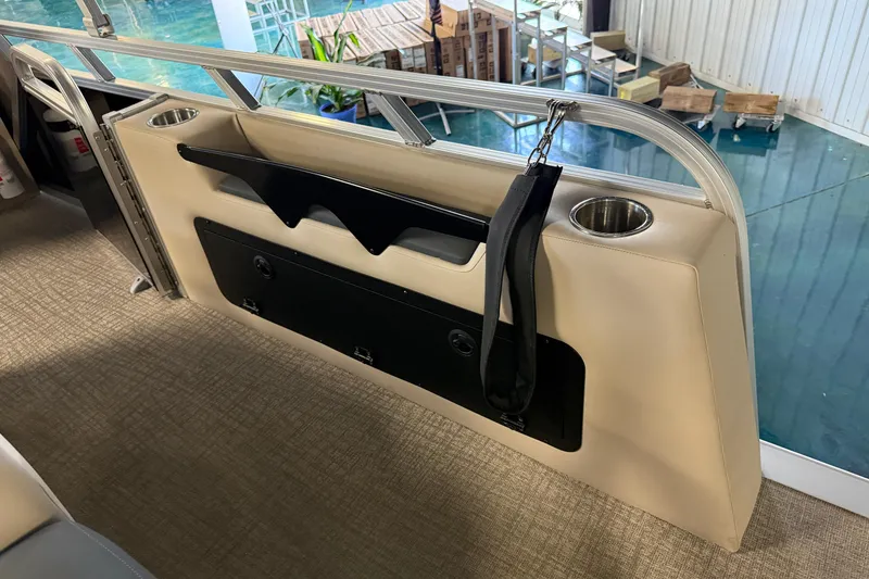 Slide: The Image of 2026 Tahoe Pontoon LTZ Entertainer interior with cup holders and storage compartment. - 7