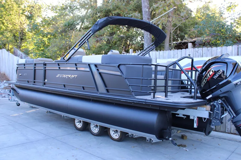Slide: The Image of 2026 Starcraft SLS 3 pontoon boat with Yamaha outboard motor, parked on a trailer. - 4