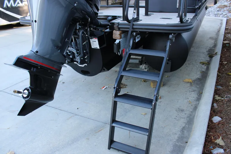 Slide: The Image of 2026 Starcraft SLS 3 boat with outboard motor and boarding ladder on a concrete surface. - 7