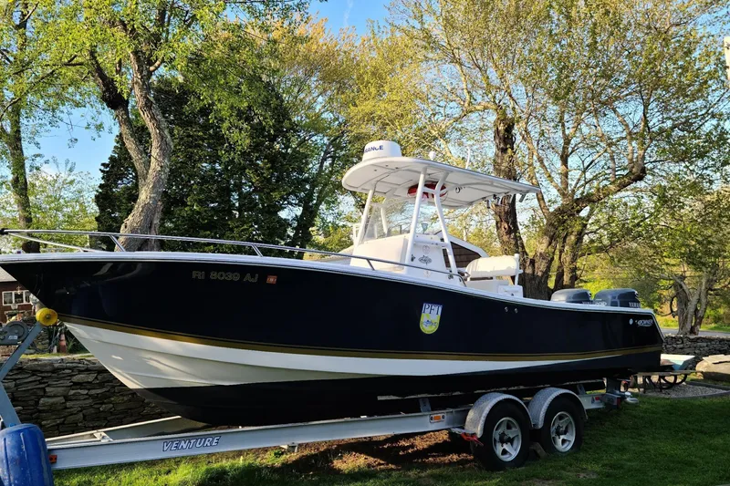 Slide: The Image of 2004 Regulator 24 Forward Seating boat on trailer, surrounded by trees. - 1