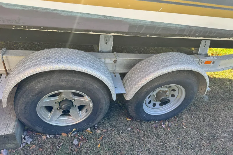 Slide: The Image of Trailer wheels of a 2004 Regulator 24 Forward Seating boat on grass. - 10