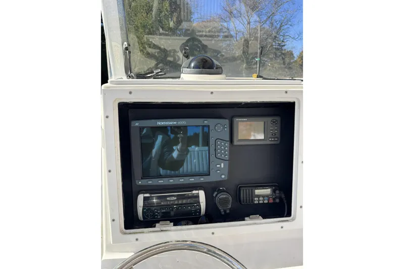 Slide: The Image of 2004 Regulator 24 Forward Seating boat dashboard with navigation and communication equipment. - 11