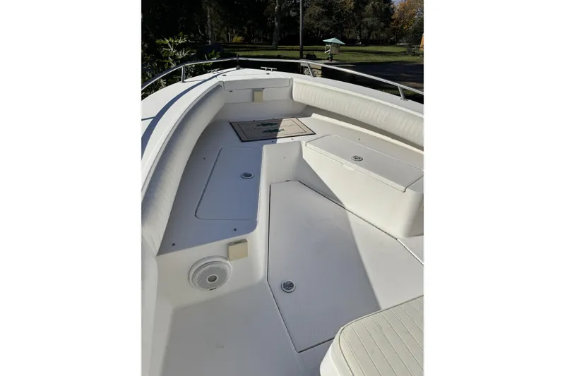Slide: The Image of 2004 Regulator 24 Forward Seating boat interior with white cushioned seats and storage compartments. - 12