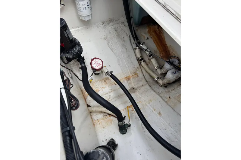 Slide: The Image of 2004 Regulator 24 Forward Seating boat interior with visible wiring and plumbing components. - 23