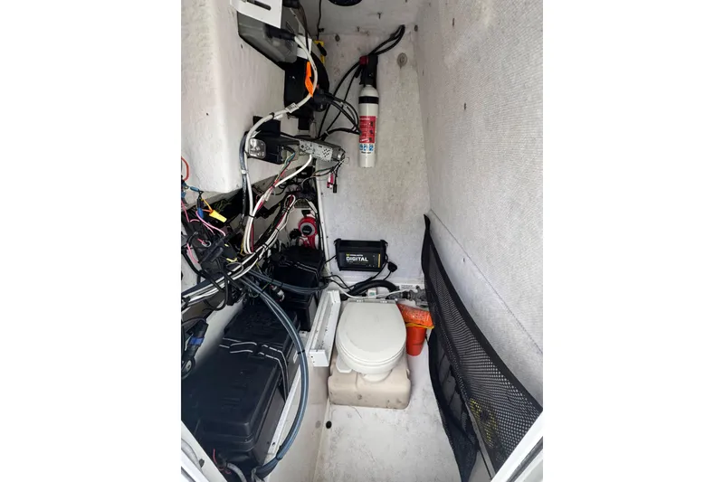 Slide: The Image of 2004 Regulator 24 Forward Seating boat interior with wiring, battery, and marine toilet. - 28