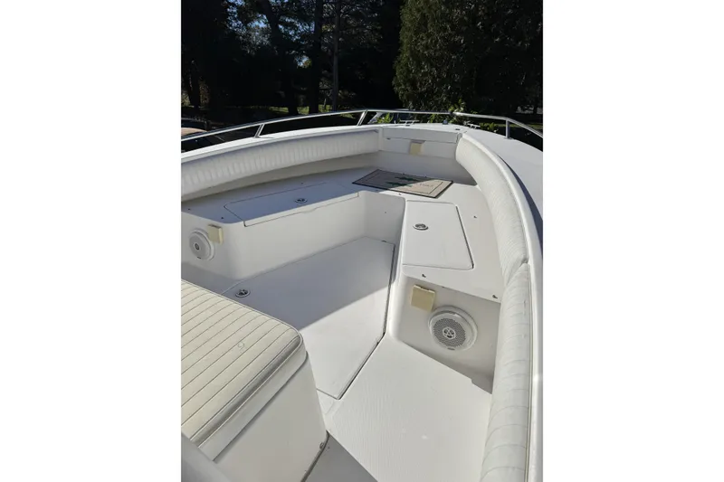Slide: The Image of 2004 Regulator 24 Forward Seating boat interior with white cushioned seating and storage compartments. - 3