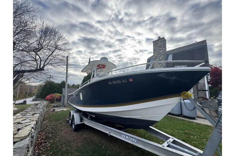 Slide: The Image of 2004 Regulator 24 Forward Seating boat on trailer, parked outdoors under cloudy sky. - 33