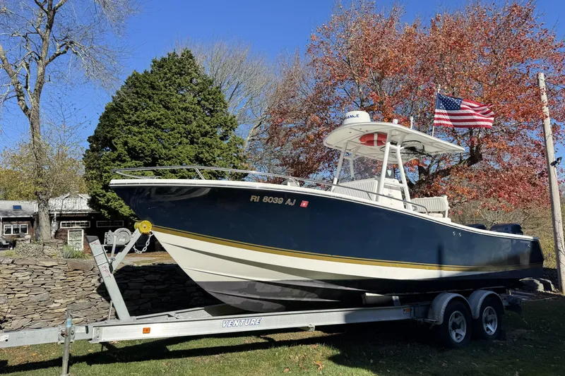 Slide: The Image of 2004 Regulator 24 Forward Seating boat on trailer, American flag, autumn trees in background. - 7