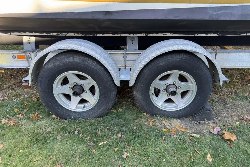 Slide: The Image of Trailer wheels of a 2004 Regulator 24 Forward Seating boat on grass. - 8