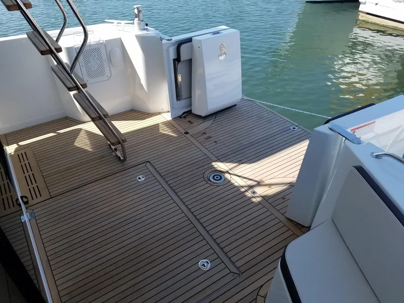 Slide: The Image of 2019 Beneteau Swift Trawler 35 deck with teak flooring and water view. - 10