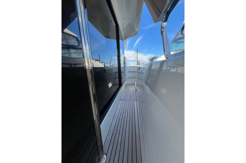 Slide: The Image of 2019 Beneteau Swift Trawler 35 side deck with sleek design and clear blue sky. - 11